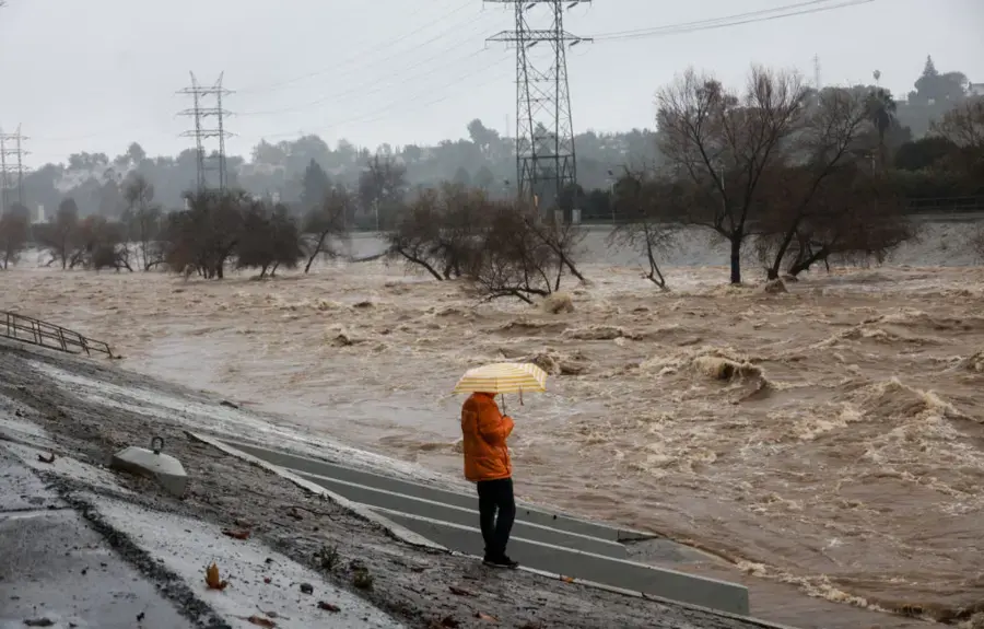 A storm-swollen wash running high below power lines during an East Valley winter storm